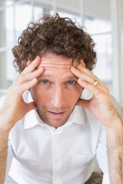 Bezorgd man zit met hoofd in handen thuis — Stockfoto