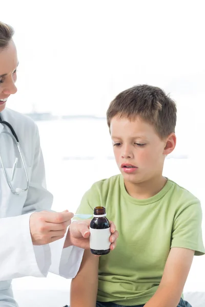 Doctor giving boy syrup — Stock Photo, Image