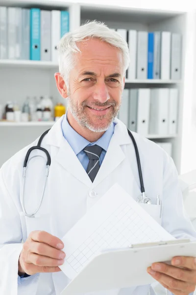 Retrato de um médico do sexo masculino com relatos em consultório médico — Fotografia de Stock