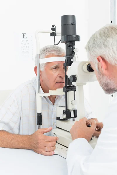 Optometrista haciendo pruebas visuales para pacientes mayores — Foto de Stock