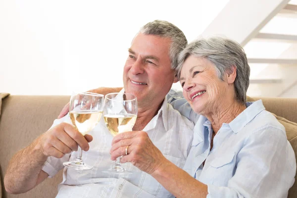 Senior koppel zittend op de Bank met witte wijn — Stockfoto