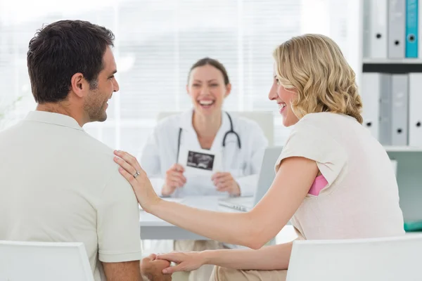 Expectant couple with doctor in clinic — Stock Photo, Image