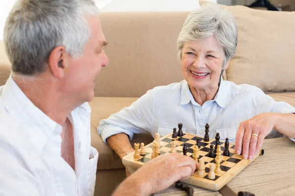 Starší pár sedící na podlaze hrát šachy — Stock fotografie