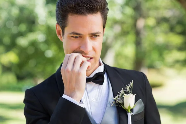 Bräutigam beißt Nägel im Garten — Stockfoto