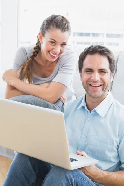 Lyckliga paret använder laptop ler mot kameran — Stockfoto