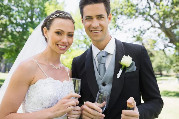 Yeni evli çift şampanya bardağı tutan — Stok fotoğraf