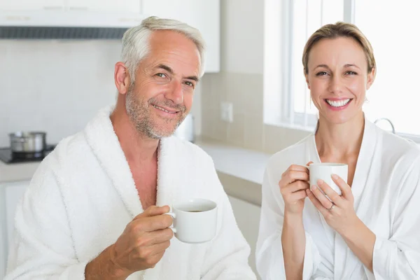 Lächelndes Paar beim Frühstück in Bademänteln — Stockfoto