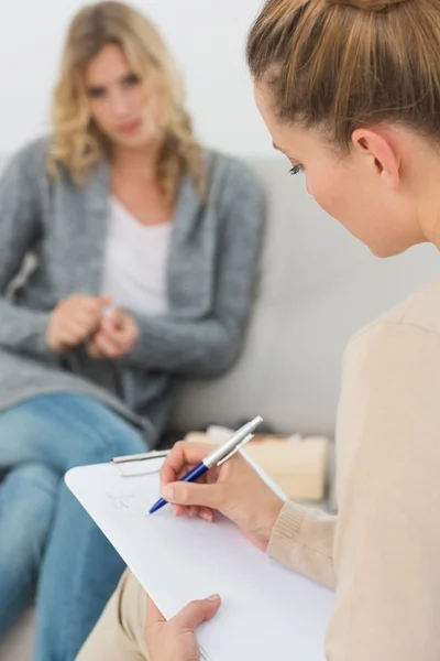 Therapist writing notes on her clipboard — Stock Photo, Image