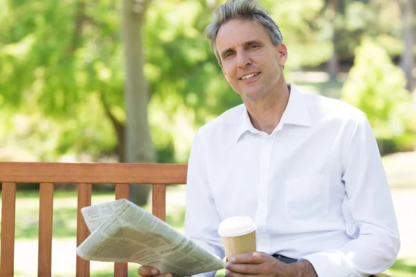 Homme d'affaires avec tasse et journal dans le parc — Photo