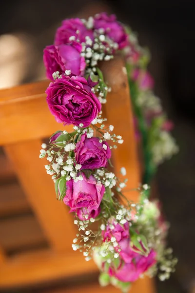 Blomma krans på en träbänk på park — Stockfoto