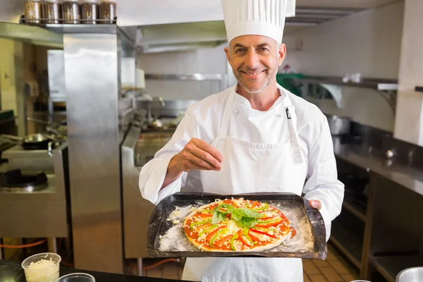 Vertrouwen mannelijke chef-kok houden gekookt voedsel in keuken — Stockfoto