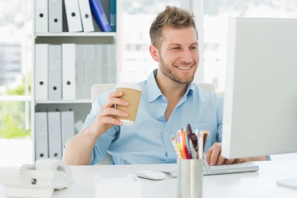 Усміхнений чоловік працює за своїм столом — стокове фото
