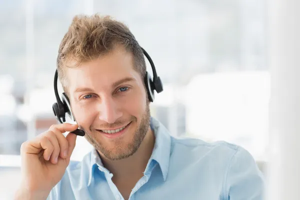 Agente sorrindo do call center usando um fone de ouvido — Fotografia de Stock