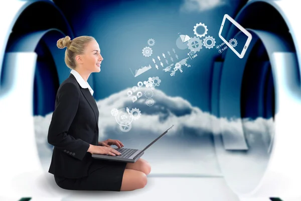 Businesswoman using laptop with cogs and wheels — Stock Photo, Image