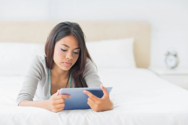 Kız onun tablet kullanarak onu yatakta yatarken — Stok fotoğraf