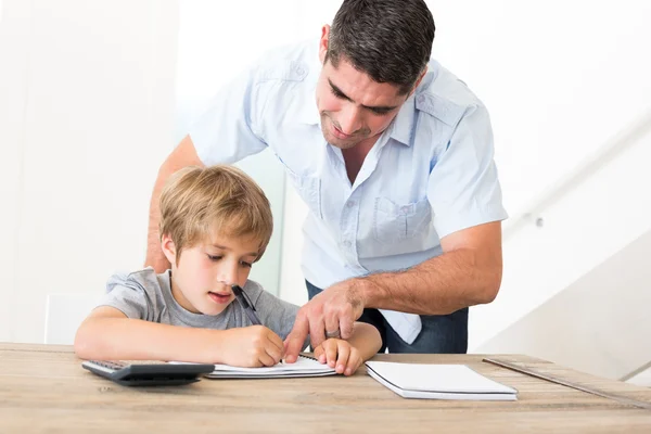 Vader meewerkende zoon in huiswerk — Stockfoto