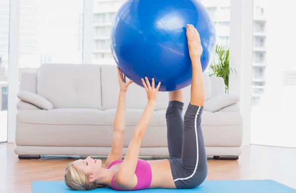 Loira segurando bola de exercício entre as pernas — Fotografia de Stock