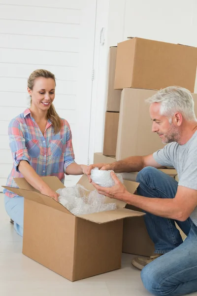 Pareja feliz desempacando cajas móviles de cartón — Foto de Stock