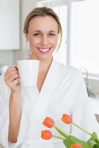 Femme souriante en peignoir debout avec tasse de café — Photo