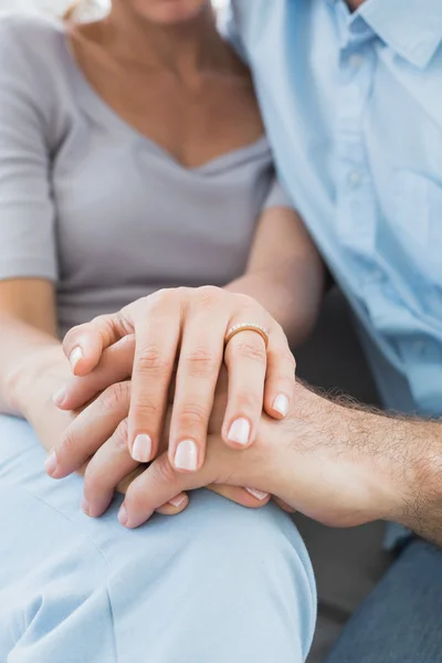 Casal mostrando anel de casamento em mulheres dedo no sofá — Fotografia de Stock