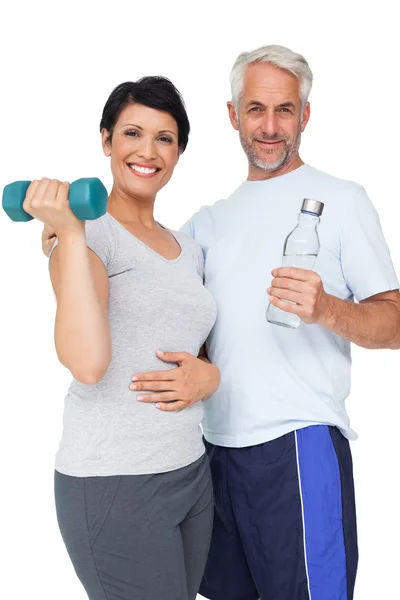 Happy fit couple with dumbbell and water bottle — Stock Photo, Image