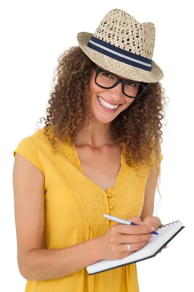 Cheerful young woman writing in notepad — Stock Photo, Image