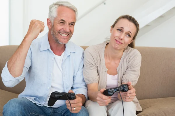 Ευτυχισμένο ζευγάρι διασκεδάζοντας στον καναπέ παίζοντας βιντεοπαιχνίδια — Φωτογραφία Αρχείου