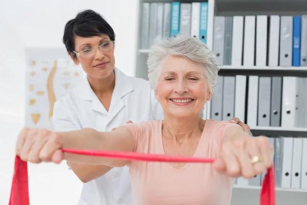 Fisioterapeuta femenina masajeando a mujeres mayores espalda —  Fotos de Stock