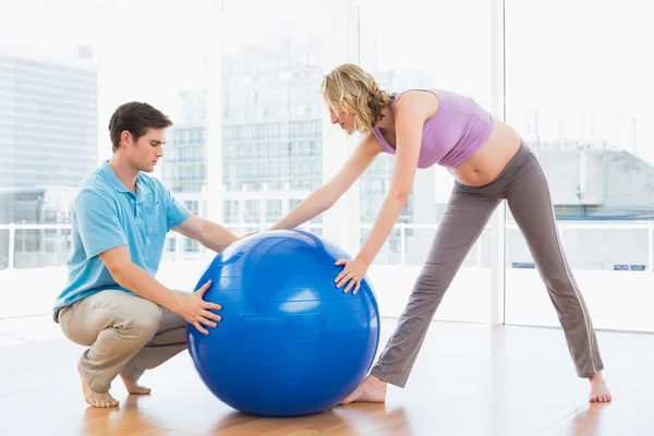 Pregnant woman exercising with trainer — Stock Photo, Image