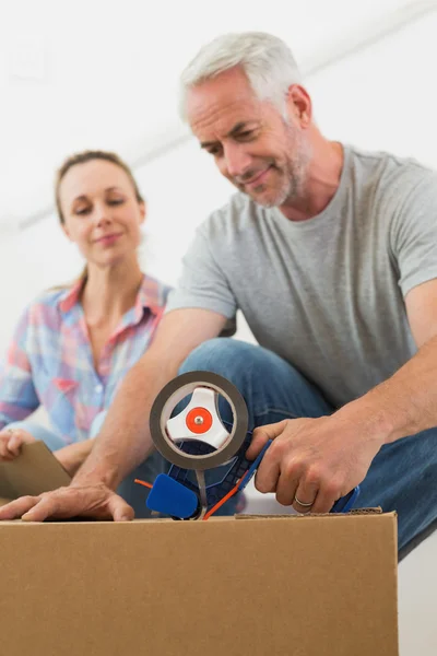 Feliz pareja sellando cajas móviles de cartón —  Fotos de Stock