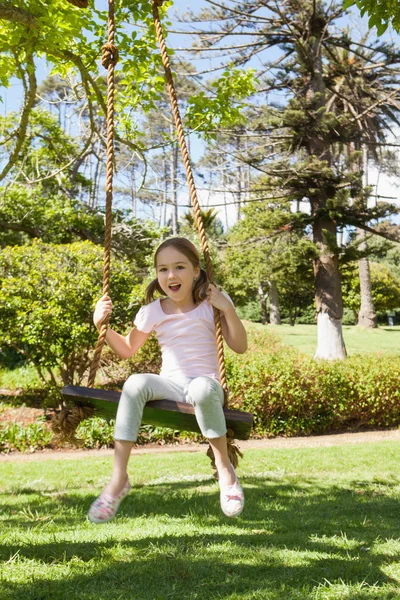 Menina sentada no balanço no parque — Fotografia de Stock