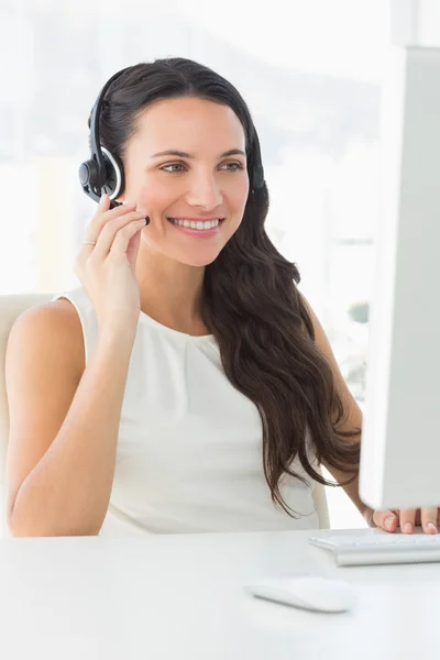 Hübsche Callcenter-Agentin sitzt bei einem Anruf an ihrem Schreibtisch — Stockfoto