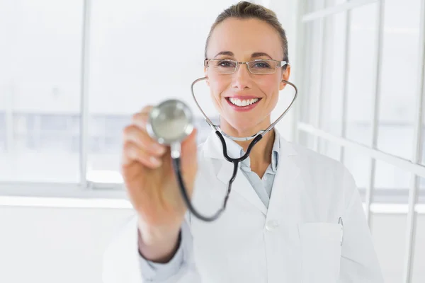 Medico sorridente femminile con stetoscopio in ospedale — Foto Stock