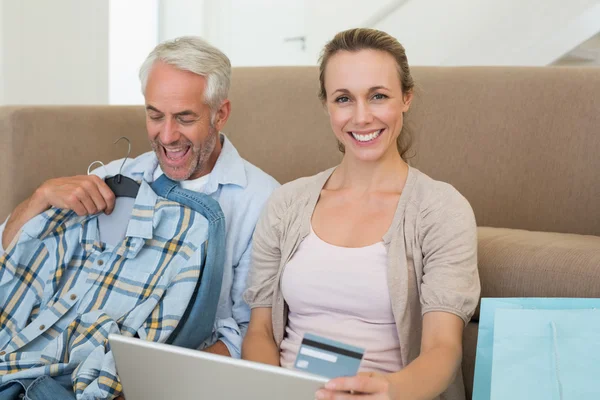 Счастливая пара совершает покупки онлайн на диване — стоковое фото