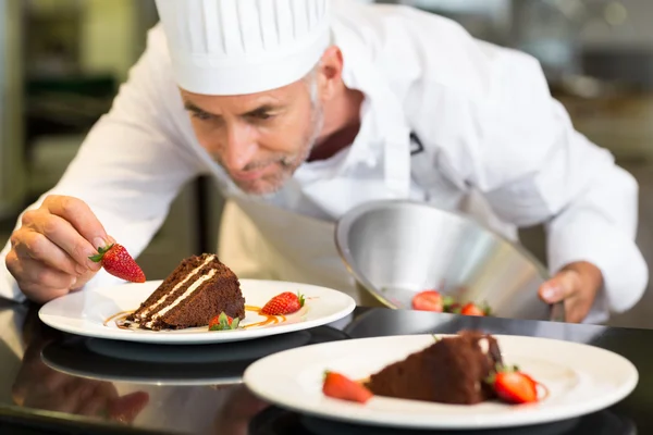 Concentrated male pastry chef decorating dessert — Stock Photo, Image