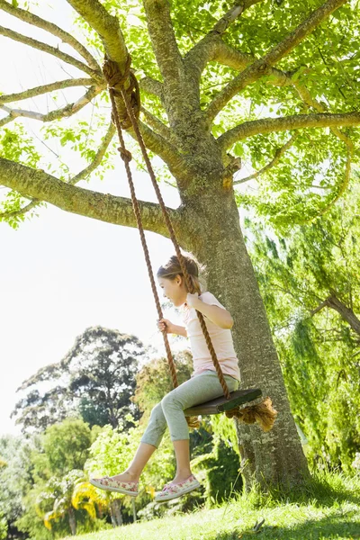 Flicka sitter på gunga på park — Stockfoto