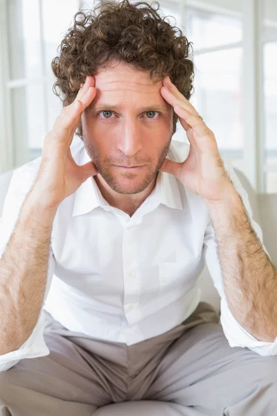 Worried well dressed man sitting with head in hands — Stock Photo, Image