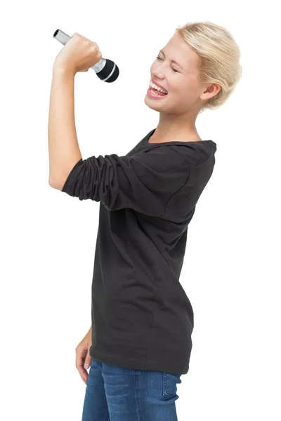 Vacker ung kvinna sjunga i en mikrofon — Stockfoto