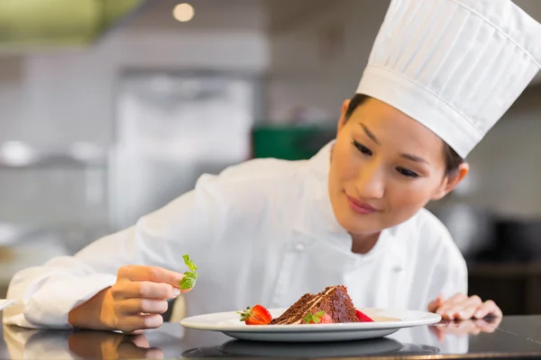 Chef feminino concentrado guarnição de alimentos na cozinha — Fotografia de Stock