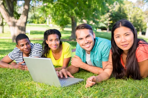 Lachende studenten met laptop op de campus — Stockfoto