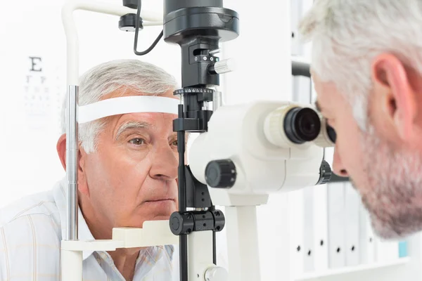 Optometrista haciendo pruebas visuales para pacientes mayores — Foto de Stock