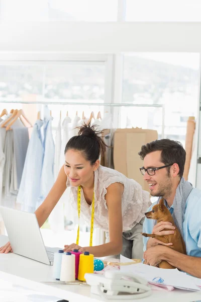 Fashion designers using laptop in studio — Stock Photo, Image