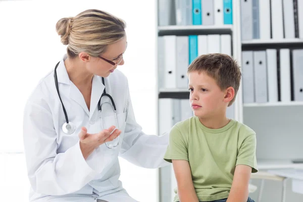 Arzt kommuniziert mit Junge in Klinik — Stockfoto