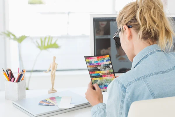 Blonde Designerin schaut auf Farbkarte — Stockfoto