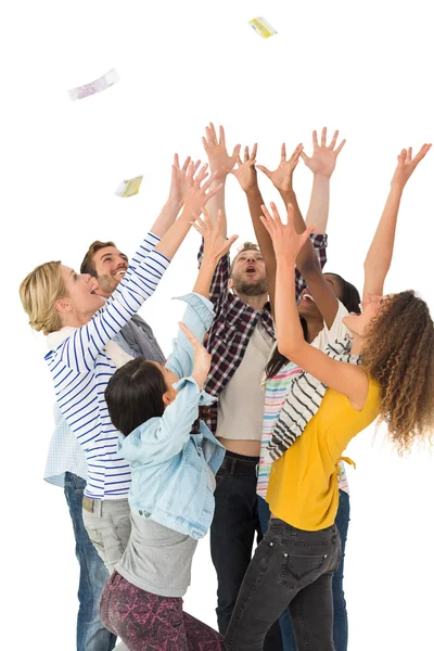 Happy group of young friends throwing money in the air — Stock Photo, Image