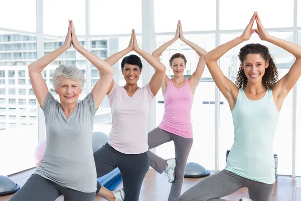 Class standing in tree pose at yoga class — Stock Photo, Image