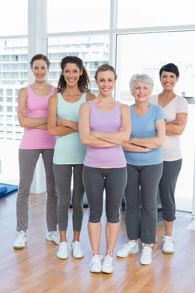 Glada kvinnor med armarna korsade i yogaklass — Stockfoto