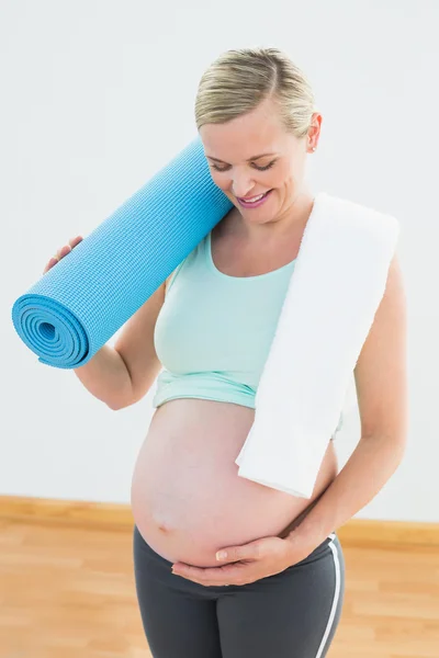 Gravid blondin håller träningsmatta — Stockfoto