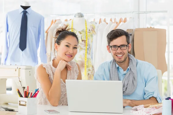 Fashion designers using laptop in studio — Stock Photo, Image