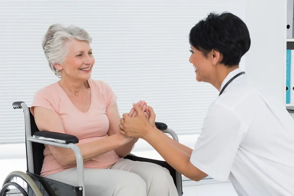 Doctor talking to a senior patient in wheelchair — Stock Photo, Image